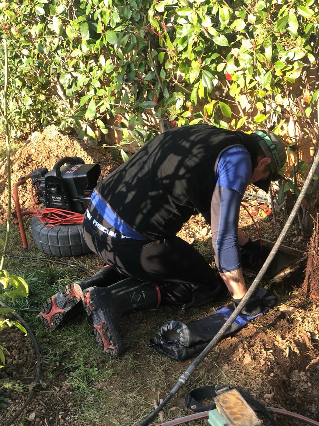Technicien passant une caméra d'inspection dans un jardin