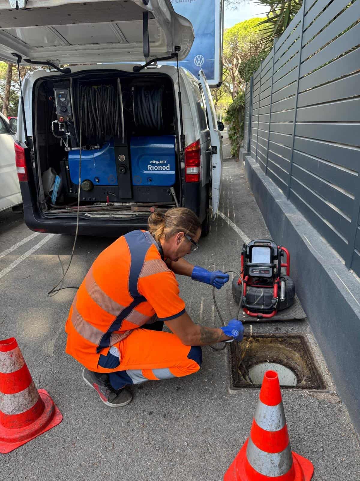 Romuald, responsable technique, passe une caméra d'inspection dans un regard devant le camion