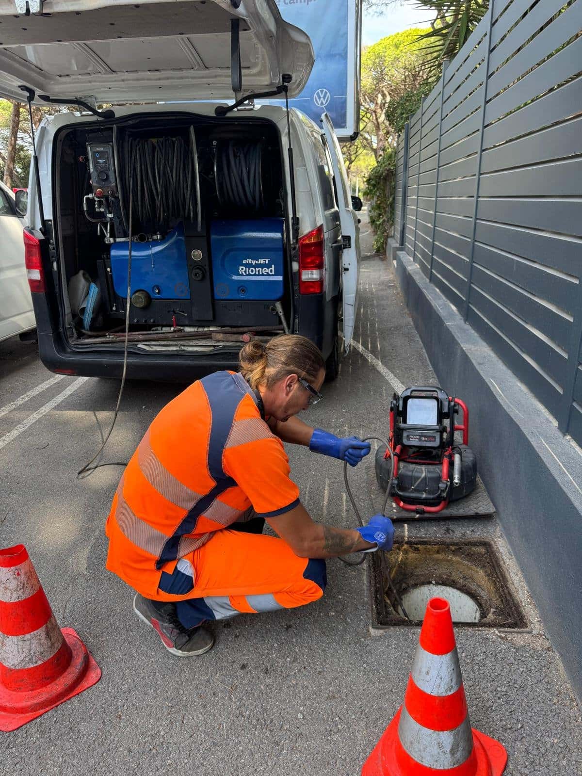Romuald, responsable technique, passe une caméra d'inspection dans un regard devant le camion